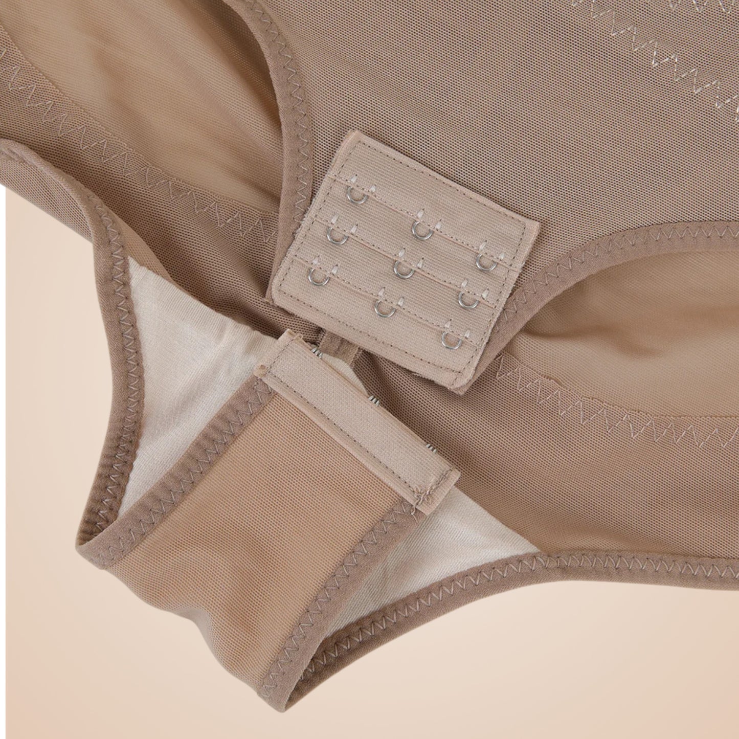 Détail du body gainant couleur nude pour femme, fermeture à agrafes réglables à l’entrejambe, couture renforcée pour un confort optimal et un maintien sculptant.