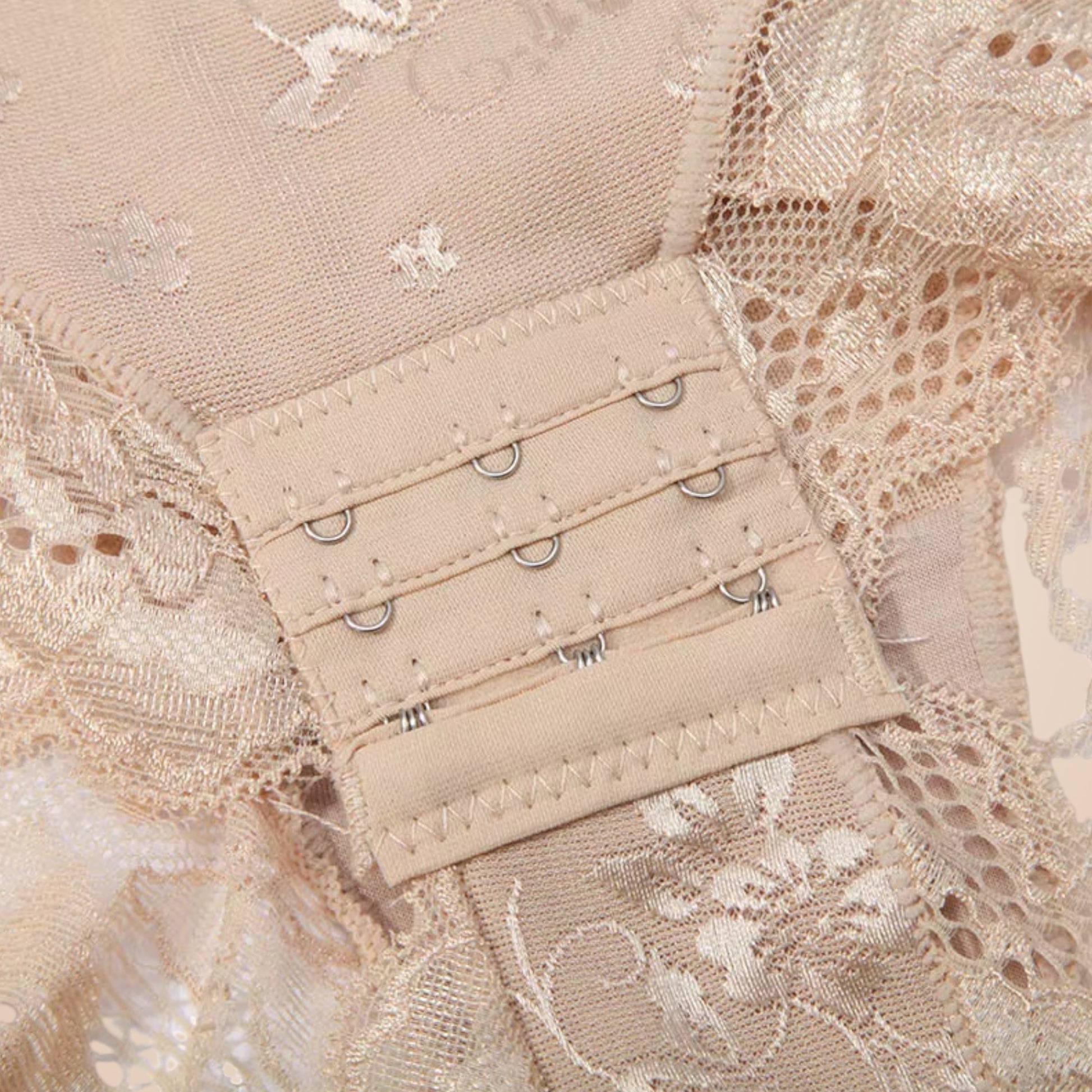 Détail du body gainant dentelle nude femme, zoom sur la fermeture à agrafes renforcées et la dentelle florale délicate, lingerie sculptante raffinée.