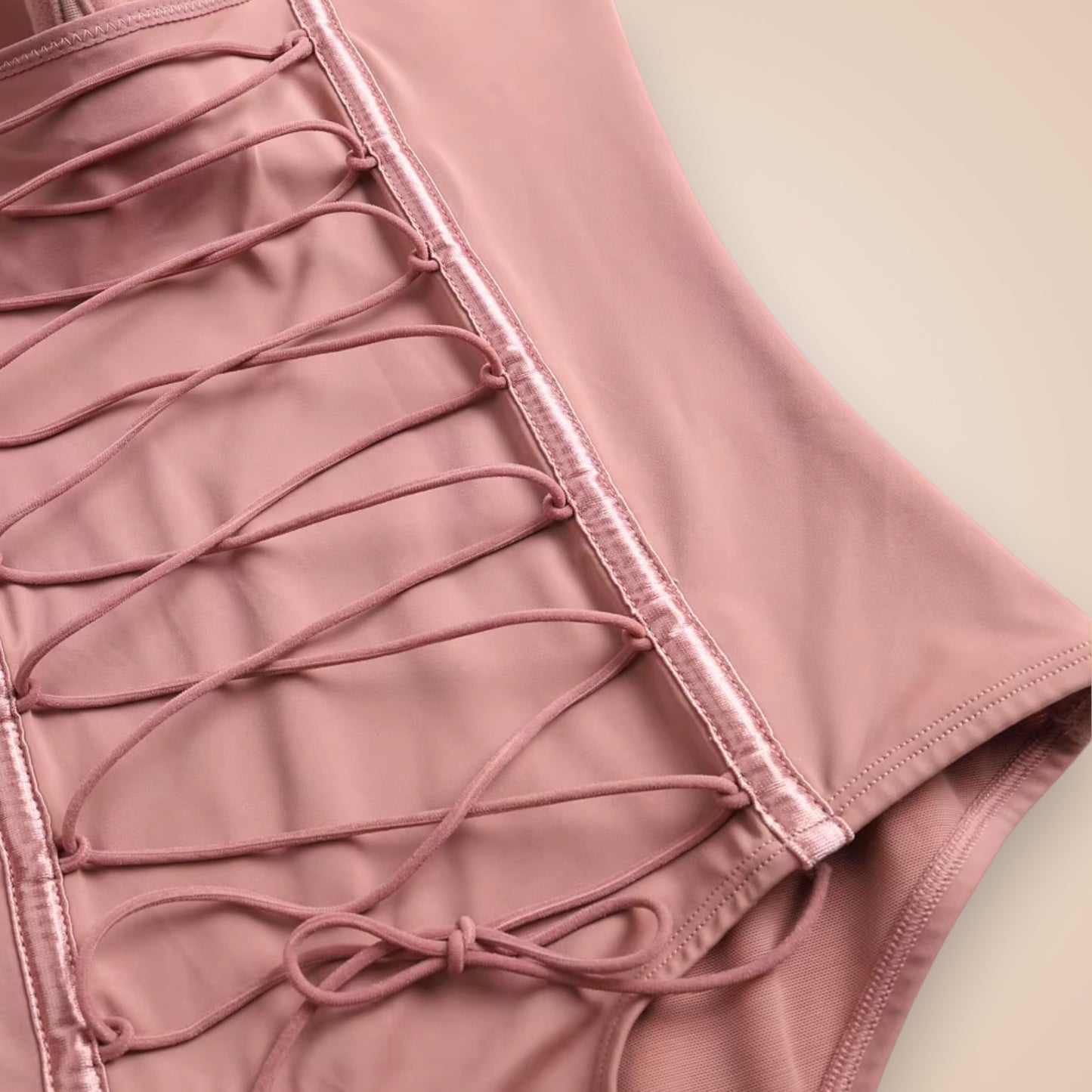 Détail du body gainant sans bretelles rose poudré, corset sculptant avec laçage ajustable pour affiner la taille et sublimer la silhouette féminine.