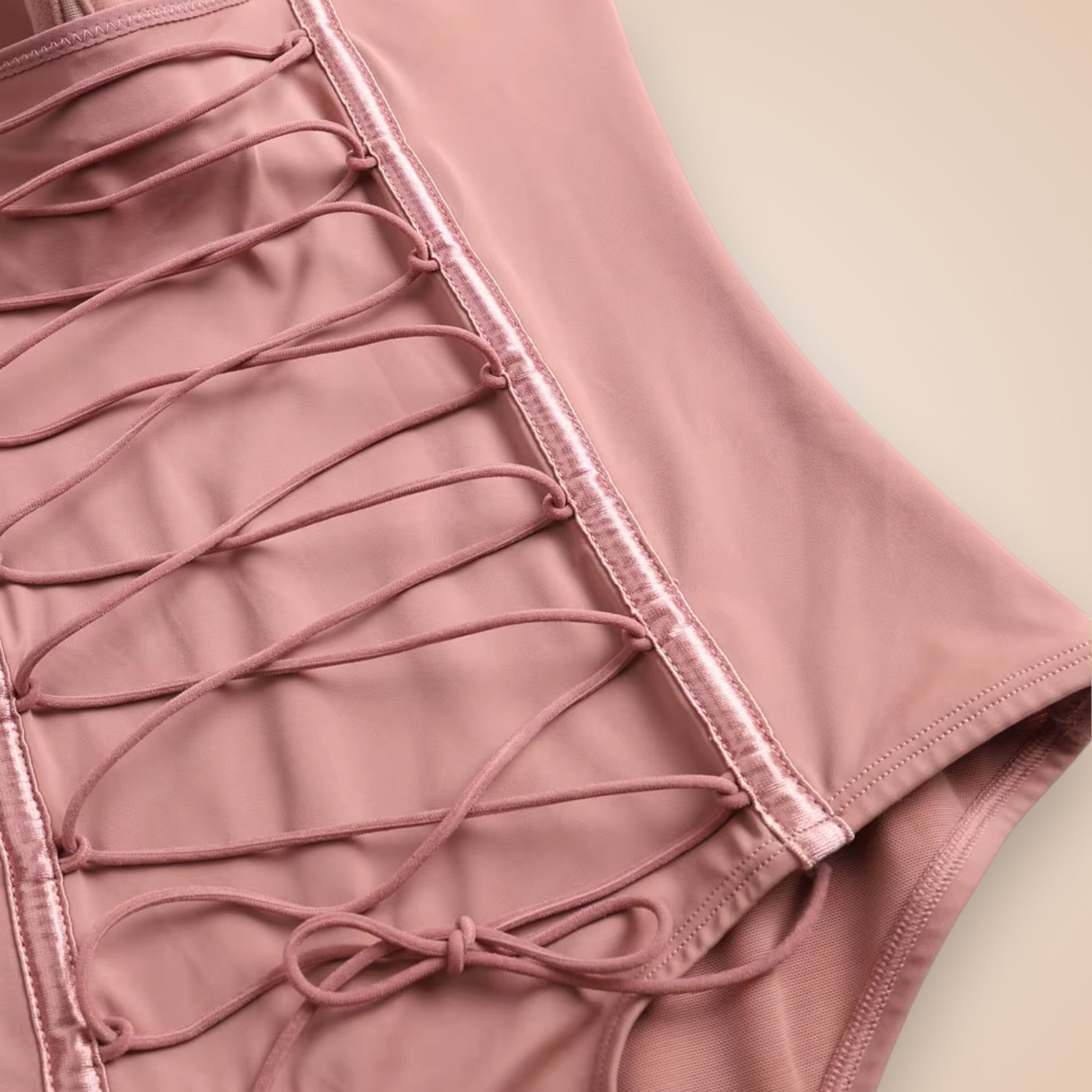 Détail du body gainant sans bretelles rose poudré, corset sculptant avec laçage ajustable pour affiner la taille et sublimer la silhouette féminine.