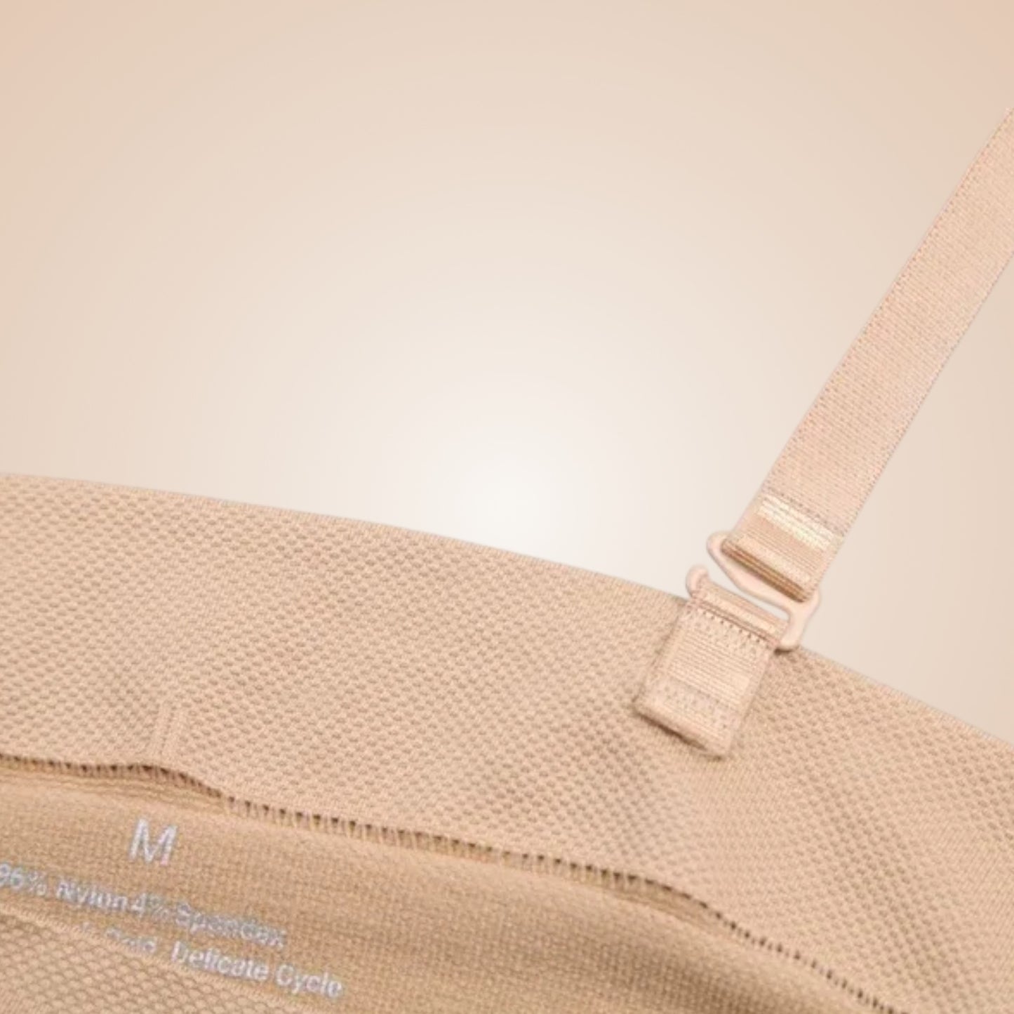 Détail de bretelle ajustable beige avec tissu texturé et bordure fine sur robe corset.